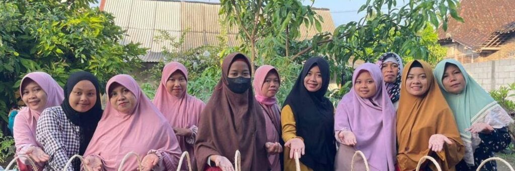 a group of women wearing headscarves smile and display woven baskets